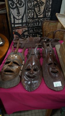 Un ensemble de quatre masques décoratifs, en bois sculpté av…