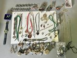 many different types of necklaces and bracelets laid out on a table