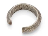 a close up of a silver bracelet on a white background