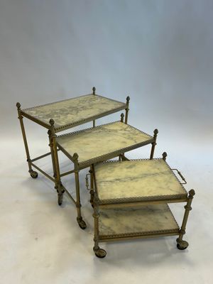 a set of three brass and marble nesting tables
