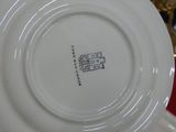 a white plate with a picture on it sitting on a red table