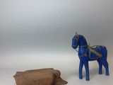 un cheval en peluche posé à côté d'une bûche