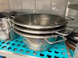 pots and pans are stacked on a shelf in a kitchen