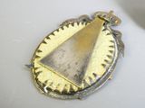 une broche en argent et en or ornée d'un triangle