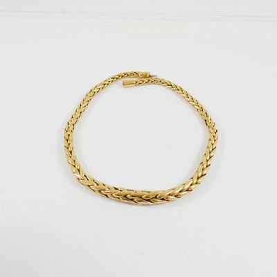un bracelet en or avec un motif de tresse sur fond blanc