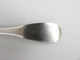 a spoon that is sitting on a white surface