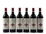 six bouteilles de vin rouge alignées sur une surface blanche