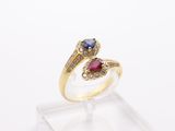 a close up of a gold ring with a blue and red stone