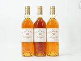 trois bouteilles de vin posées les unes à côté des autres sur une surface blanche
