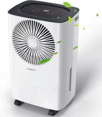 a white air conditioner with green leaves flying around it