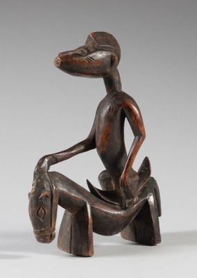 an image of a wooden sculpture of a man sitting on a horse