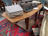 a table with a typewriter on it in a room full of antique furniture