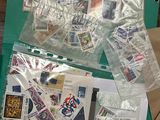 un sachet de timbres posé sur une table à côté d'une paire de ciseaux et d'une paire de ciseaux