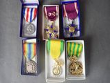 several medals and medals are in small boxes on a table
