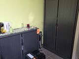 une armoire noire et une chaise noire dans un coin de la pièce