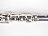a close up of a silver and black clarinet on a white surface