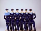 several figurines of men dressed in blue uniforms stand in a row