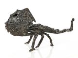 a bronze sculpture of a scorpion on a white surface