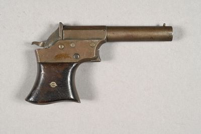 un vieux pistolet posé sur une surface blanche