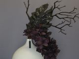 a white vase with a plant in it on a table