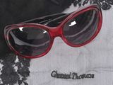 a red pair of sunglasses sitting on top of a lace tablecloth