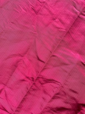 pink bed sheet with a pink pillow on top of it