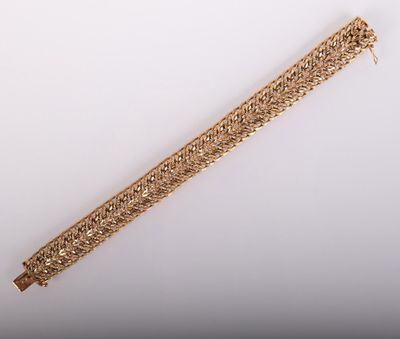 a close up of a gold bracelet on a white surface