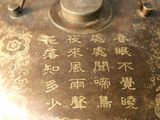 a metal teapot with writing on it on a table