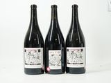 trois bouteilles de vin posées sur une table blanche