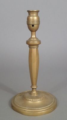 Bougeoir en laiton fondu, à décor de godrons et de perles.