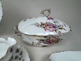 a white table topped with a bowl and a bowl with flowers on it