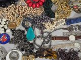 many different types of necklaces and bracelets laid out on a table