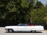 a white car parked in a parking lot with trees in the background
