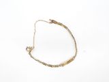 a close up of a gold bracelet on a white surface