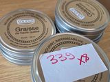 three tins of wax sitting on top of a wooden table