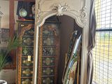 a large mirror in the corner of a room next to a cabinet