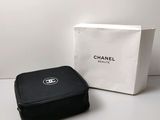 un étui noir orné du logo Chanel, à côté d'une boîte blanche