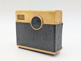 a black and gold camera sitting on top of a white table