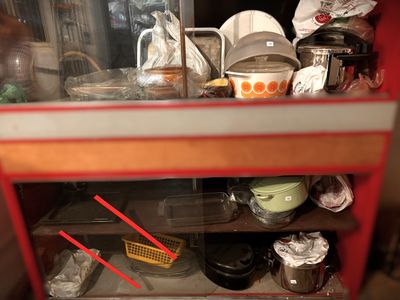 a red cabinet filled with dishes and utensils
