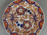 une assiette orange, bleue et blanche ornée d'un motif floral