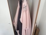 une armoire avec des vêtements suspendus à l'intérieur, dans un coin de la pièce