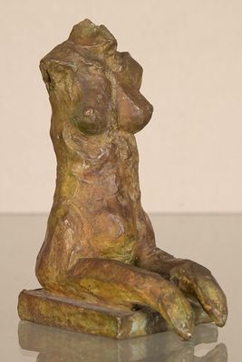 statue of a woman sitting on a table with her hands on her knees
