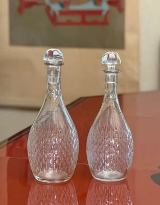 two glass salt and pepper shakers sitting on a table