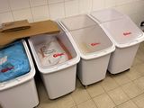 several trash cans are lined up in a row in a public restroom
