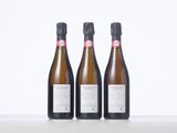 three bottles of wine sitting on top of a white table