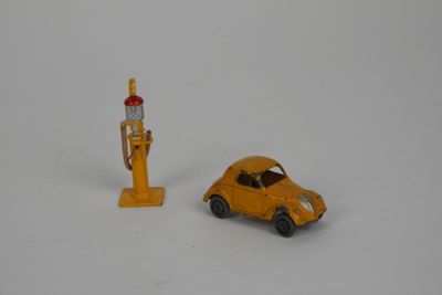 a small toy car next to a gas pump on a white surface