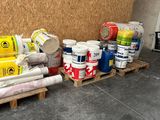 plusieurs rouleaux de peinture sur une palette près d'un mur