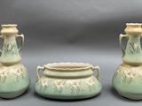 trois vases posés l'un à côté de l'autre sur une table