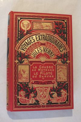 un vieux livre à la couverture rouge posé sur une table blanche