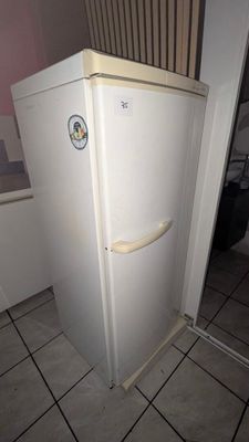 a white refrigerator sitting in the corner of a room